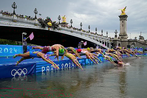Athletes dive into the water for the start of the women's triathlon competition